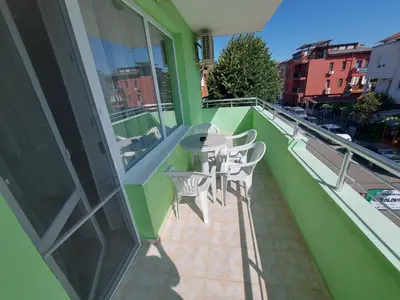 a balcony with a table and chairs on a building at Guest House Nikolovi in Lozenets
