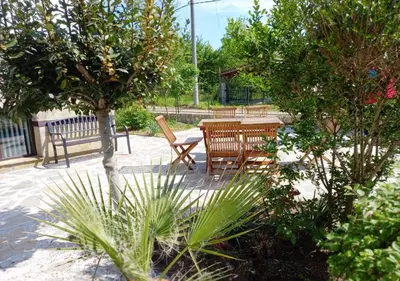 a patio with a table and chairs and trees at Villa Kalina in Lozenets
