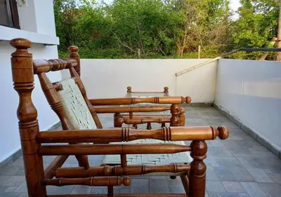 three wooden rocking chairs sitting on a porch at Villa Kalina in Lozenets