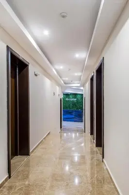 an empty hallway with white walls and floors and doors at Семеен хотел Адена in Chernomorets
