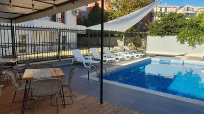 a patio with a table and chairs next to a pool at Family Hotel Saga in Ravda