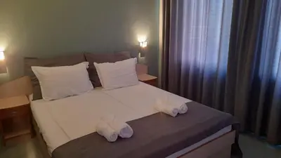a bedroom with a large white bed with two pillows at Family Hotel Saga in Ravda
