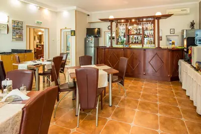 a restaurant with tables and chairs and a bar at Hotel Tropics & Venera - Ultra All Inclusive in Sveti Vlas