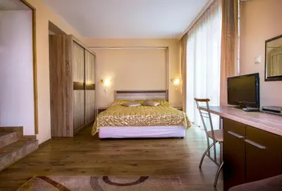 a bedroom with a bed and a desk and a television at Hotel Tropics & Venera - Ultra All Inclusive in Sveti Vlas