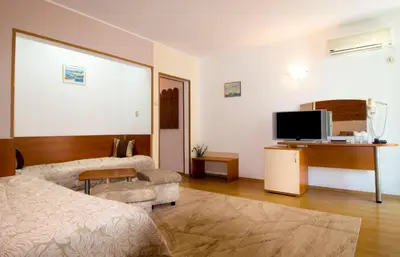 a bedroom with a bed and a tv and a couch at Hotel Tropics & Venera - Ultra All Inclusive in Sveti Vlas
