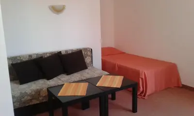 a room with a couch and a bed and a table at Hotel Bellisimo in Lozenets