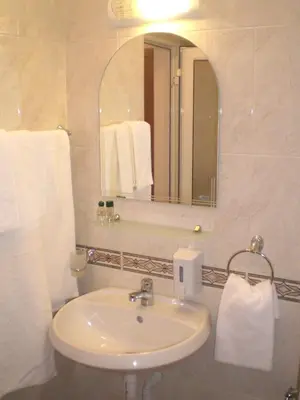 a bathroom with a sink and a mirror and towels at Hotel Bellisimo in Lozenets