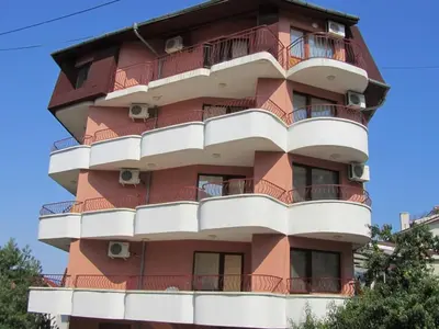 a tall red building with balconies at House Sofia in Sveti Vlas