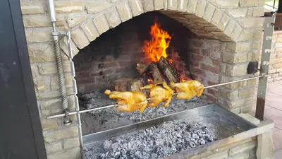 a brick oven with chickens cooking in it at Complex Strandzhata in Burgas City