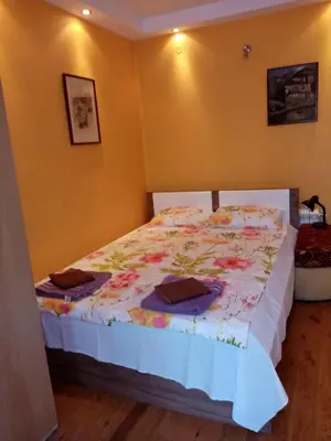 a bedroom with a bed in a room with yellow walls at House Prodanovi in Sozopol