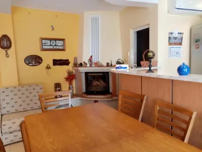 a dining room with a table and a fireplace at House Prodanovi in Sozopol