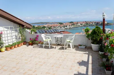 a patio with two chairs and a table on a balcony at House Prodanovi in Sozopol