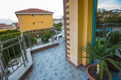a balcony of a building with a potted plant at JBH Hotel in Sveti Vlas