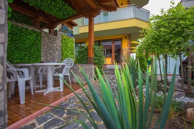 a patio with a table and chairs in front of a building at JBH Hotel in Sveti Vlas
