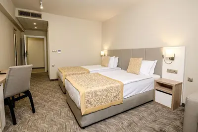 a hotel room with two beds and a desk at Hotel Laguna Park Sunrise in Sunny Beach