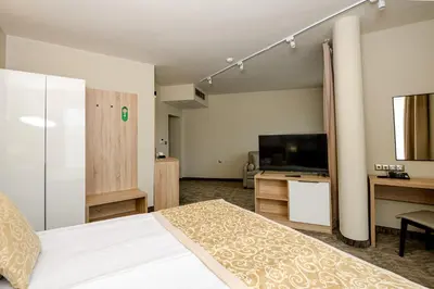 a bedroom with a bed and a desk and a television at Hotel Laguna Park Sunrise in Sunny Beach