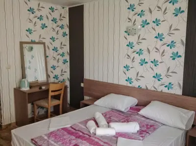 a bedroom with a bed with towels on it at Morska Zvezda Guest House in Chernomorets