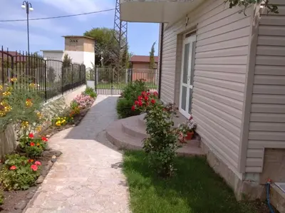 a walkway next to a house with flowers at Morska Zvezda Guest House in Chernomorets