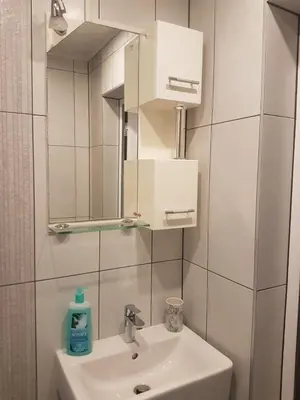 a white bathroom with a sink and a mirror at Odessus in Varna City