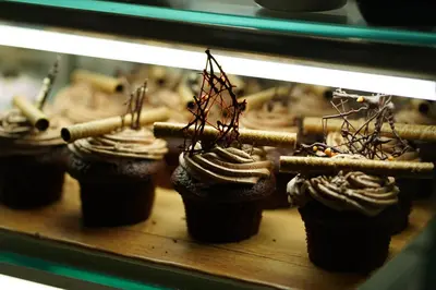 a group of chocolate cupcakes in a display case at Wave Resort - Ultra All Inclusive in Pomorie