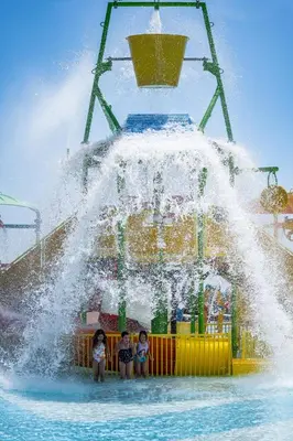 three children are standing in a fountain at a water park at Wave Resort - Ultra All Inclusive in Pomorie