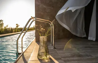 a vase with flowers in it next to a pool at Wave Resort - Ultra All Inclusive in Pomorie