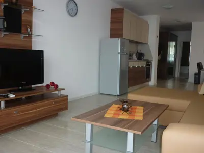 a living room with a television and a table at Ganozliev's Apartments in Kavatsi Area in Sozopol