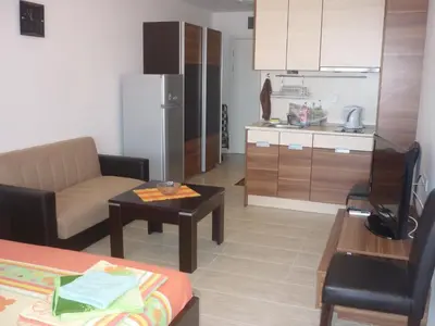 a kitchen and a living room with a couch and a table at Ganozliev's Apartments in Kavatsi Area in Sozopol