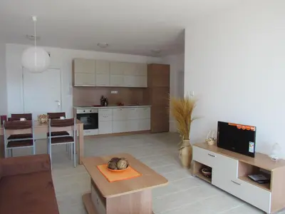 a living room with a kitchen and a dining room at Ganozliev's Apartments in Kavatsi Area in Sozopol