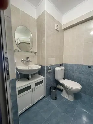 a bathroom with a toilet and a sink and a mirror at Guest house Marina in Obzor