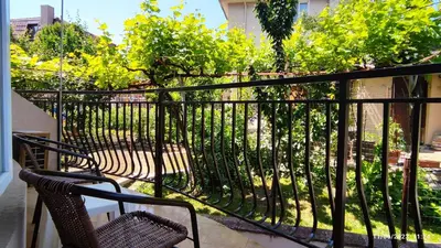 a balcony with two chairs and a fence at Guest house Marina in Obzor