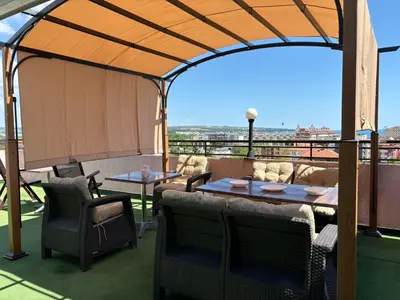a gazebo with a table and chairs on a roof at Guest house Marina in Obzor