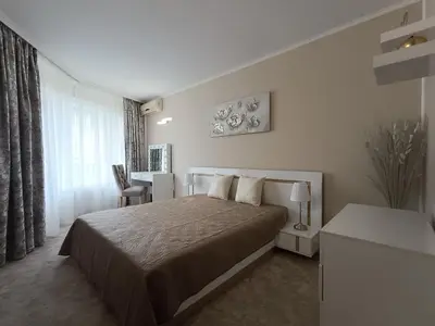 a bedroom with a bed and a table and a desk at Guest house Marina in Obzor