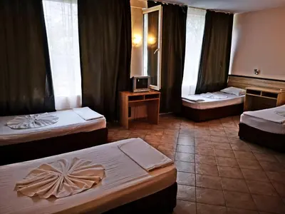 a hotel room with two beds and a television at Hotel Varly Bryag in Burgas City