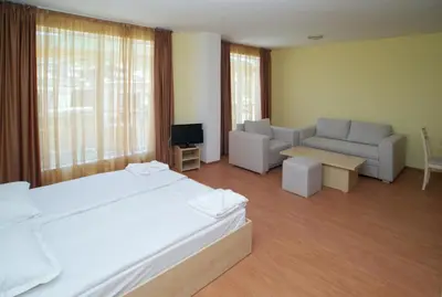 a bedroom with a bed and a couch and a tv at Aparthotel Anixi in Obzor