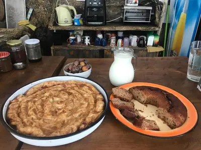 a table topped with a pie and a plate of meat at Guest House Dara in Tsarevo