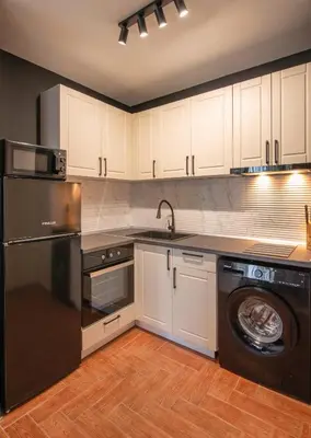 a kitchen with a black refrigerator and a dishwasher at Messambria Beach Apartments in Sveti Vlas