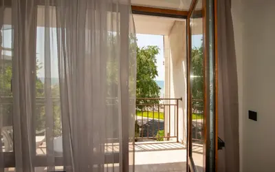 a room with a window with a view of a balcony at Messambria Beach Apartments in Sveti Vlas