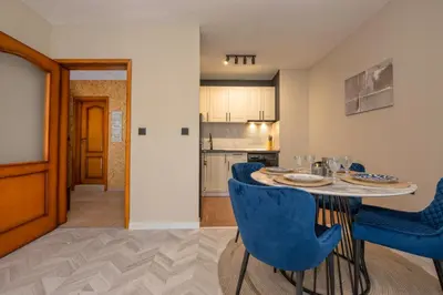 a dining room with a table and blue chairs at Messambria Beach Apartments in Sveti Vlas
