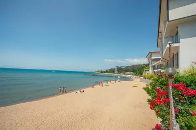 a beach with a group of people and the water at Messambria Beach Apartments in Sveti Vlas