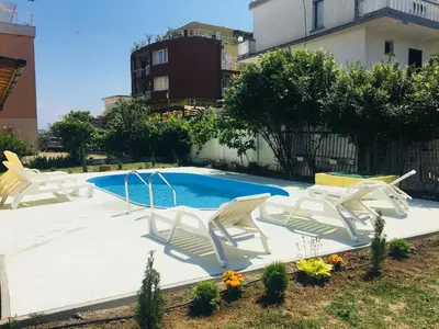 a group of white chairs sitting around a swimming pool at Hotel Elmaz in Lozenets