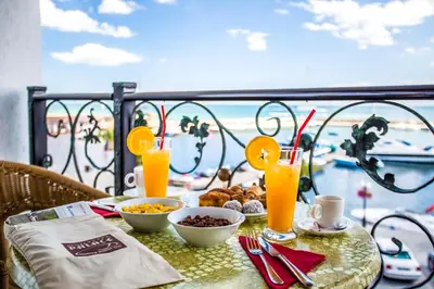 a table with food and drinks on a balcony at Hotel Palace Marina Dinevi in Sveti Vlas