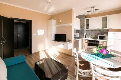 a kitchen and living room with a blue couch and a table at Apartment Cathedral Deluxe in Varna City