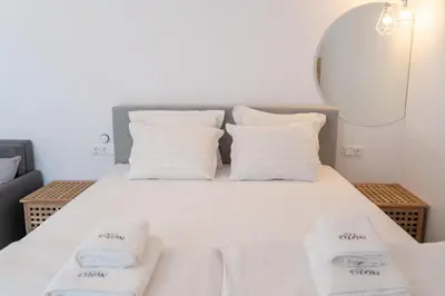 a bedroom with a bed with white sheets and pillows at Dion Apartments in Lozenets