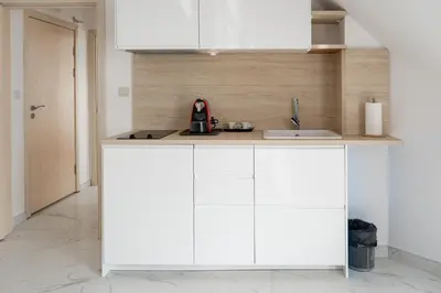 a kitchen with white cabinets and a sink at Dion Apartments in Lozenets