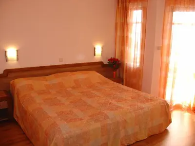 a bedroom with a bed with a quilt on it at Family Hotel Saint Nikola in Nesebar