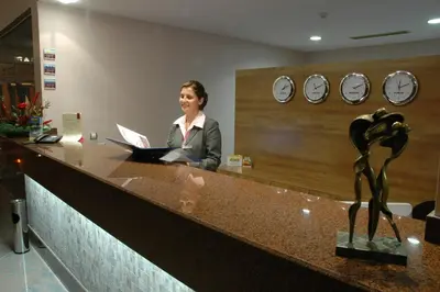 a woman sitting at a reception desk with a laptop at Jeravi Beach Hotel - All Inclusive in Sunny Beach