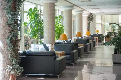 a row of couches in a lobby with plants at Jeravi Beach Hotel - All Inclusive in Sunny Beach