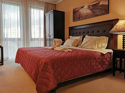 a bedroom with a large bed with a red blanket at ROYAL BEACH HOTEL apartment in Sunny Beach
