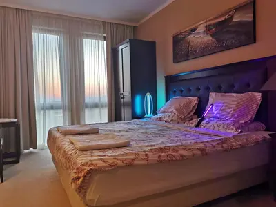a bedroom with a large bed with a blue headboard at ROYAL BEACH HOTEL apartment in Sunny Beach